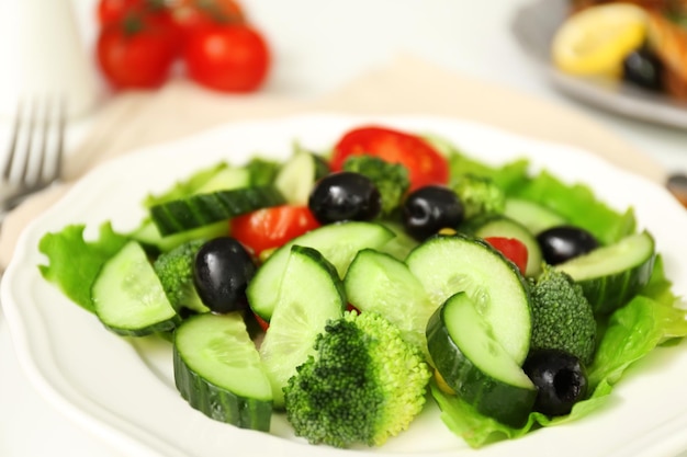 Plate with salad on table