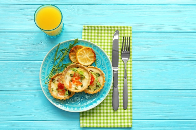 Plate with salmon tartlets on table