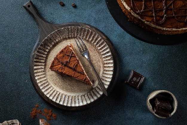 사진 파란색 배경에 맛있는 홈메이드 초콜릿 케이크 조각이 있는 접시 텍스트를 위한 공간 케이크 플랫레이 초콜릿 케이크 조각