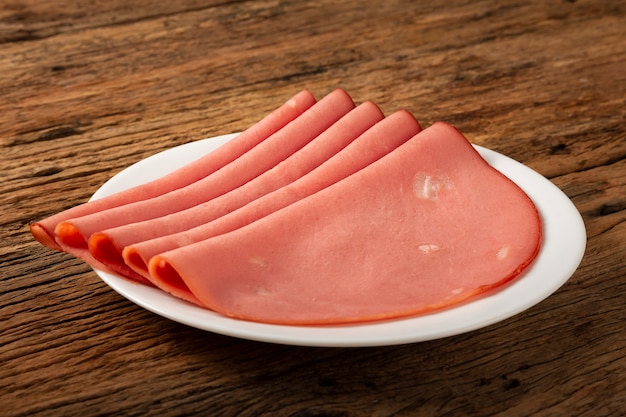 Plate with sliced mortadella on the table