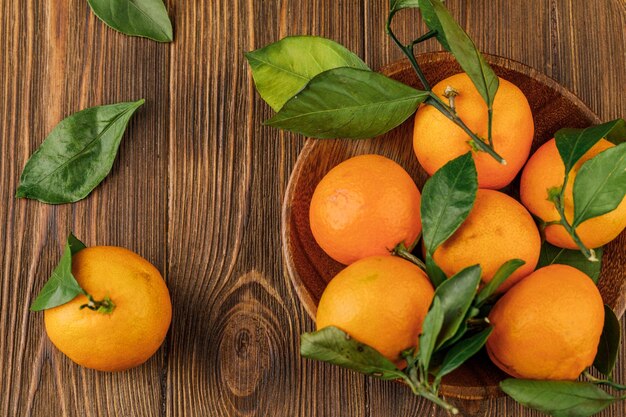 Plate with some tangerines on wooden table