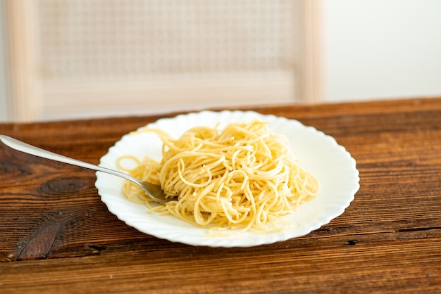Plate with spaghetti on wooden background