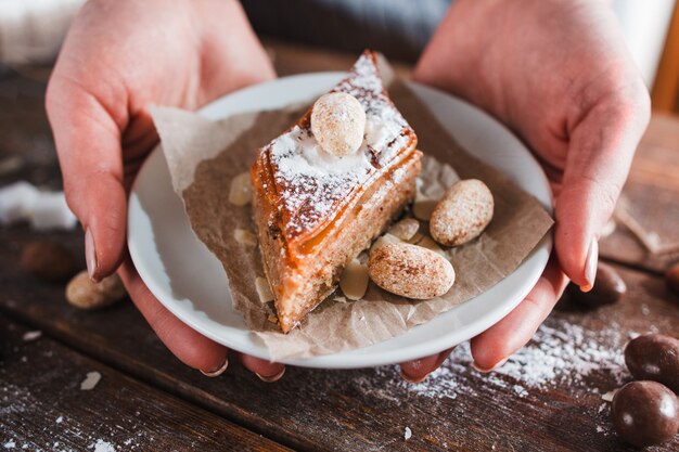 Foto piastra con baklava dolce in primo piano delle mani di donna.