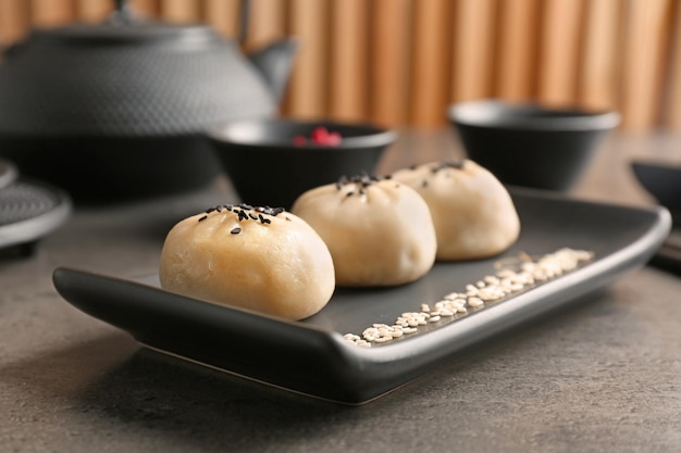 Plate with tasty baozi dumplings on table