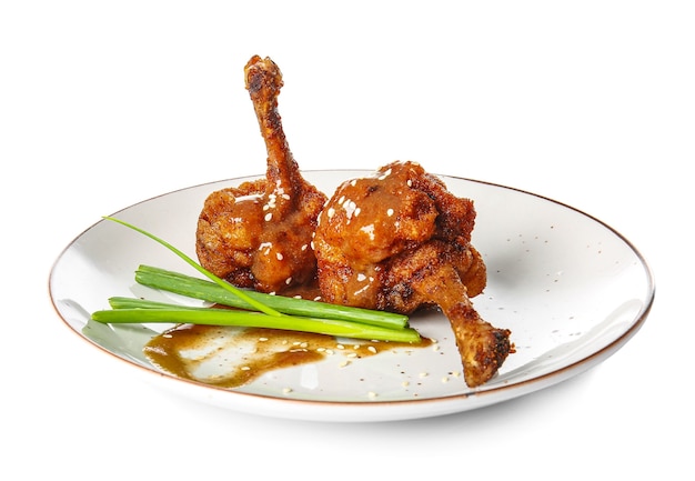 Plate with tasty chicken lollipops on white surface