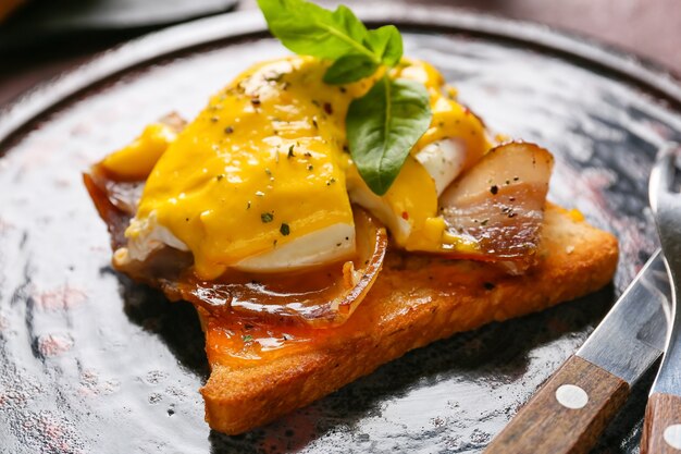 Plate with tasty egg Benedict on table, closeup