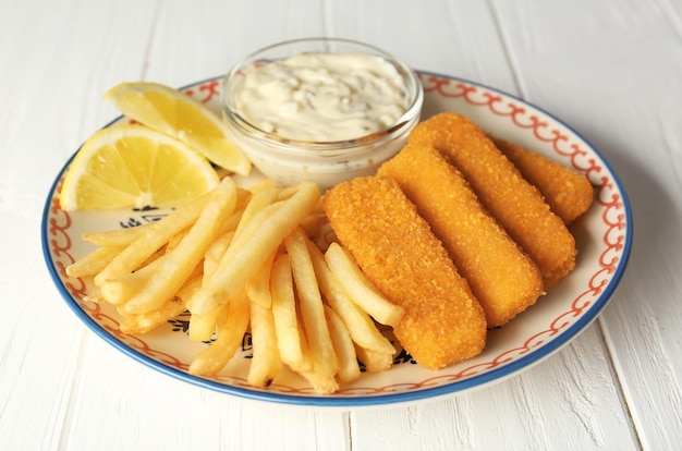 木製のテーブルの上に美味しい魚のナゲット ⁇ 揚げ物とソースが入った皿