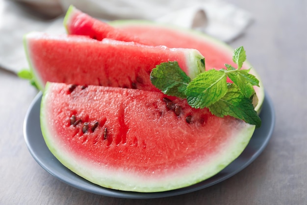 Plate with tasty sliced watermelon on table