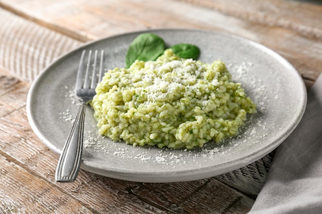 Photo plate with tasty spinach risotto on table closeup