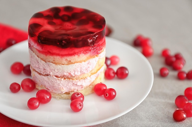 Plate with tasty sponge cake on table