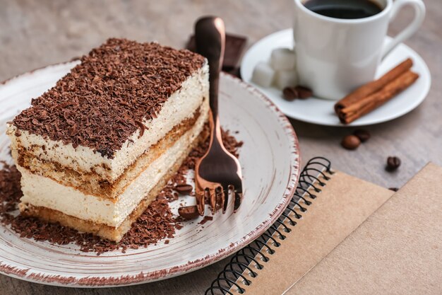 Plate with tasty tiramisu on grey table