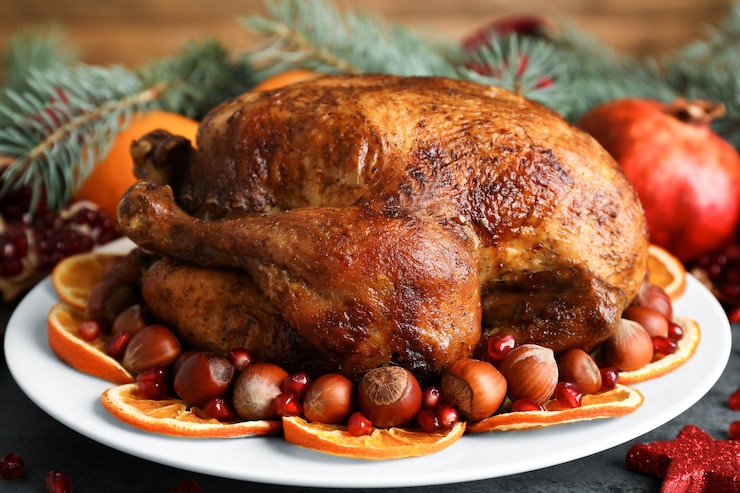 Photo plate with tasty whole roasted turkey on table