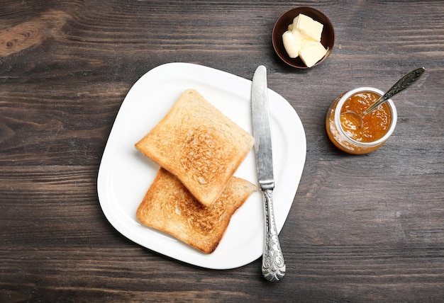 Plate with toasted bread on table