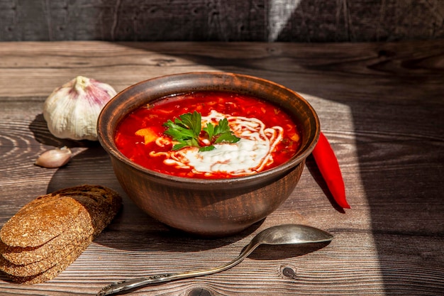 Plate with Ukrainian borscht on a wooden background