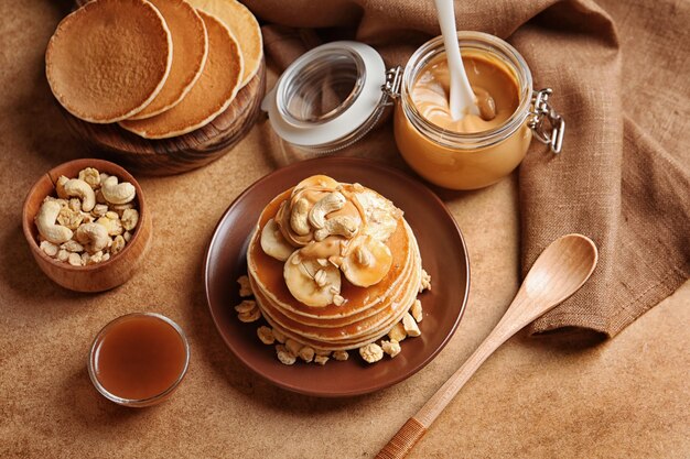 Plate with yummy banana pancakes on kitchen table