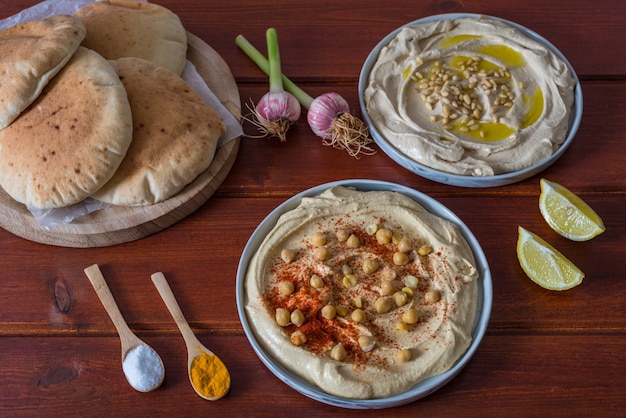 Foto platen van hummus met pitabroodje op houten rode achtergrond