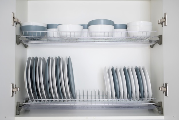 The plates are flat and deep stacked on the dryer in the kitchen