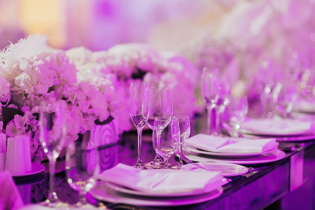 Plates and glasses at served festive table ready Flowers on the table