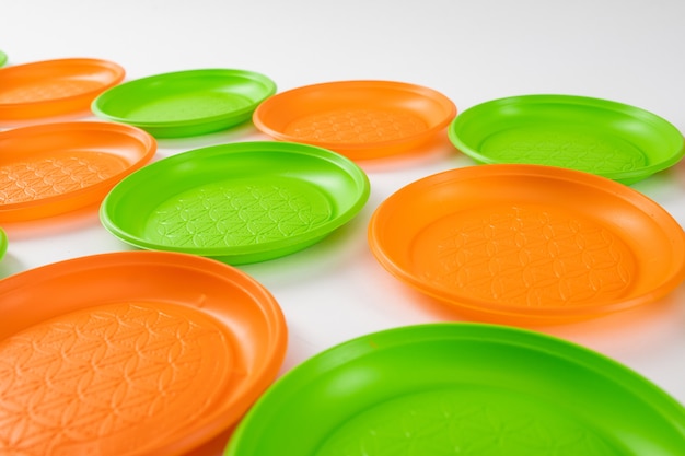 Тарелки рядами. Дешевая пластиковая посуда для повседневного использования, сложенная вместе и заботящаяся об окружающей среде.
