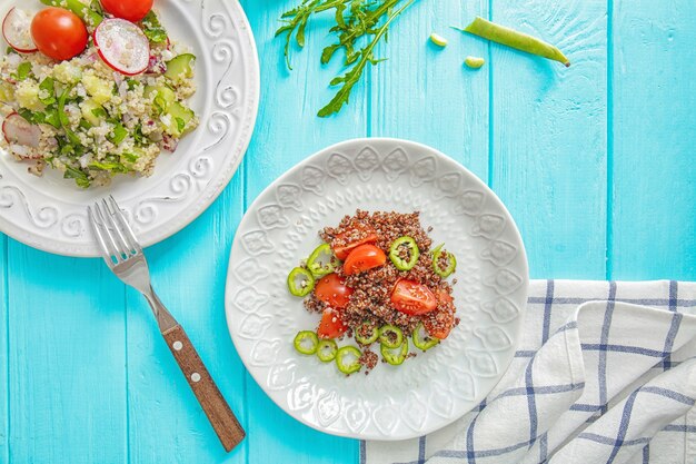 Plates with quinoa salad on table