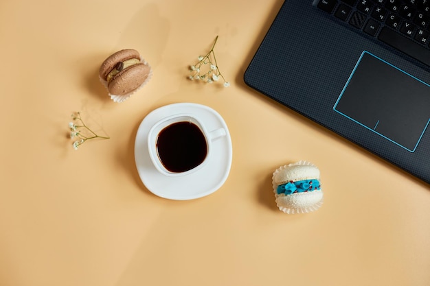 Platliggend bovenaanzicht kantoortafel bureau werkruimte met laptop macaron met koffiekopje