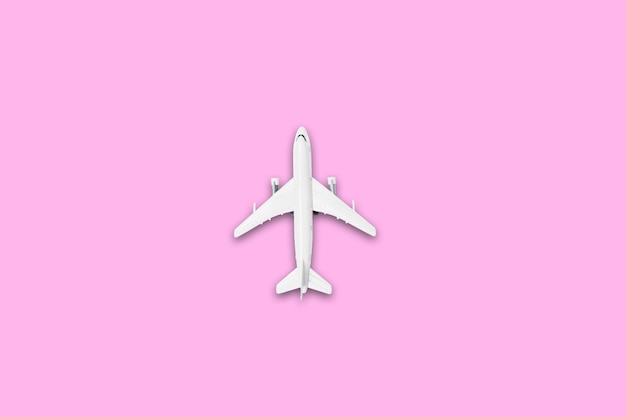 Platliggend ontwerp van reizen in zomerconcept Bovenaanzicht van een vliegtuig op blanco roze pastelkleurenscherm met kopie ruimtevaart op zomervakantie