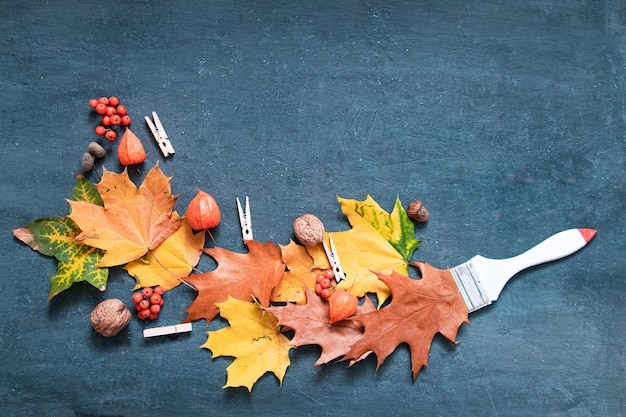 Foto platliggende herfst oranje kleur bladeren, borstel, physalis, lijsterbes bovenaanzicht