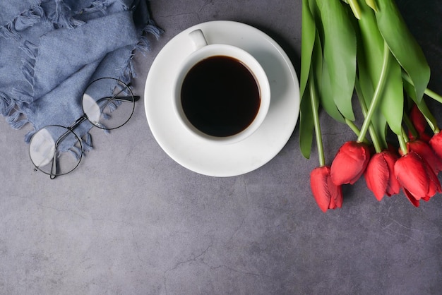 Platte compositie koffie tulp bloem en lenzenvloeistof op zwarte achtergrond