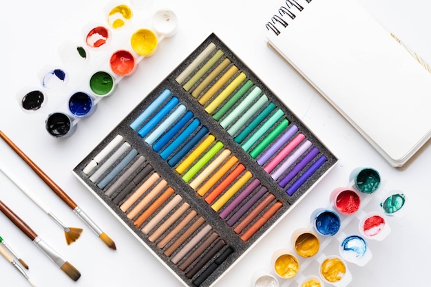 Foto platte compositie set artistieke gereedschappen borstels verven potloden pastels om te tekenen plaats voor tekst