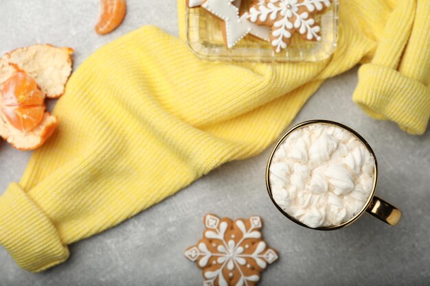 Platte lay-compositie met heerlijk marshmallow-drankje en gele trui op lichtgrijze tafel