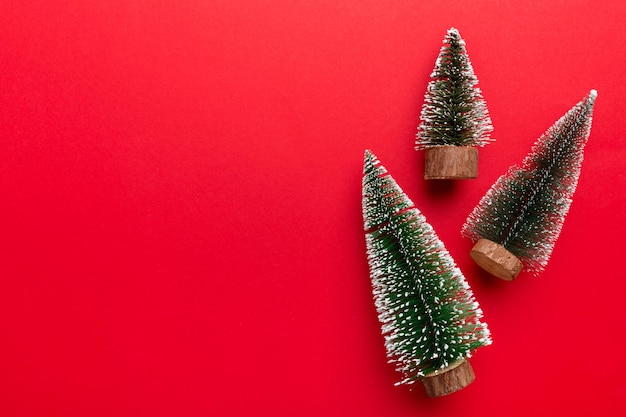 Platte lay compositie met kerstbomen op gekleurde achtergrond Bovenaanzicht met kopieerruimte