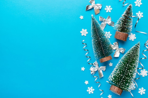 Platte lay compositie met kerstbomen op gekleurde achtergrond Bovenaanzicht met kopieerruimte