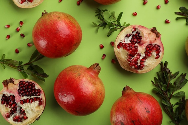 Platte lay compositie met rijpe granaatappels op groene achtergrond