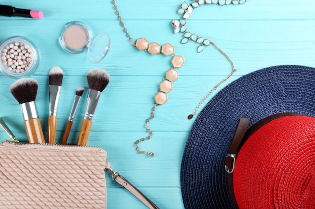 Foto platte lay van vrouwelijke cosmetica en accessoires op blauwe houten achtergrond