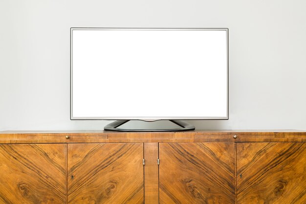 Platte lcd-televisie op bruin houten kast in de woonkamer met een wit scherm