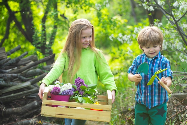 Platteland jeugd jonge generatie boomknuffelaars en natuurliefhebbers jeugd en outdoor vrijetijdsconcept schattige kleine jongen en meisje planten in de tuin water te geven op zonnige lentedag