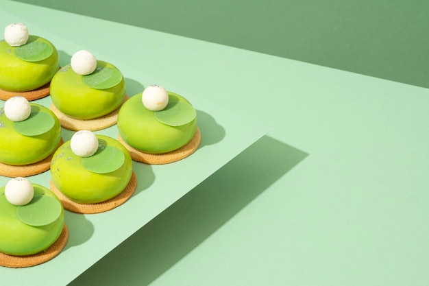 Foto un piatto di ciambelle verdi assortite si trova in cima a un tavolo di legno