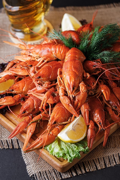 A platter of crayfish with a glass of beer on the side.