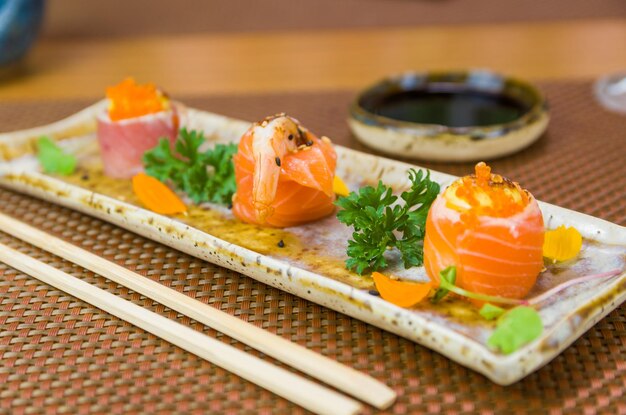 Platter decorated with different flavors of elegant sushi Selective focus