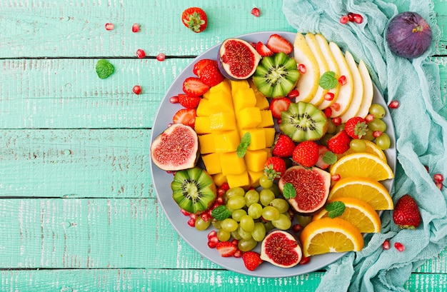 Platter fruits and berries. Mango, kiwi, fig, strawberry, grapes, pear and orange. 