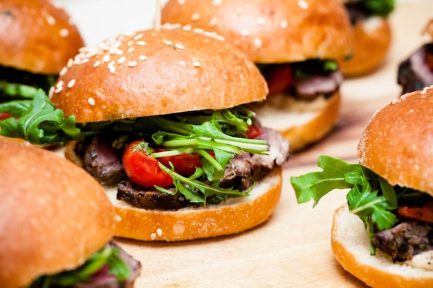 A platter full of hamburgers ready for consumption