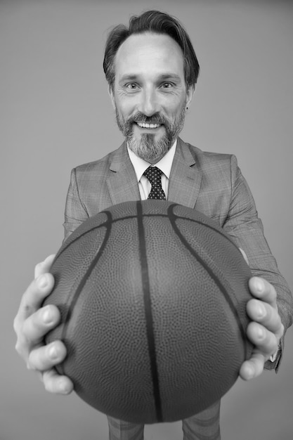 Play basketball be happy happy businessman hold basketball ball\
basketball coach grey background basketball coaching business and\
sport competition competitive game play hard