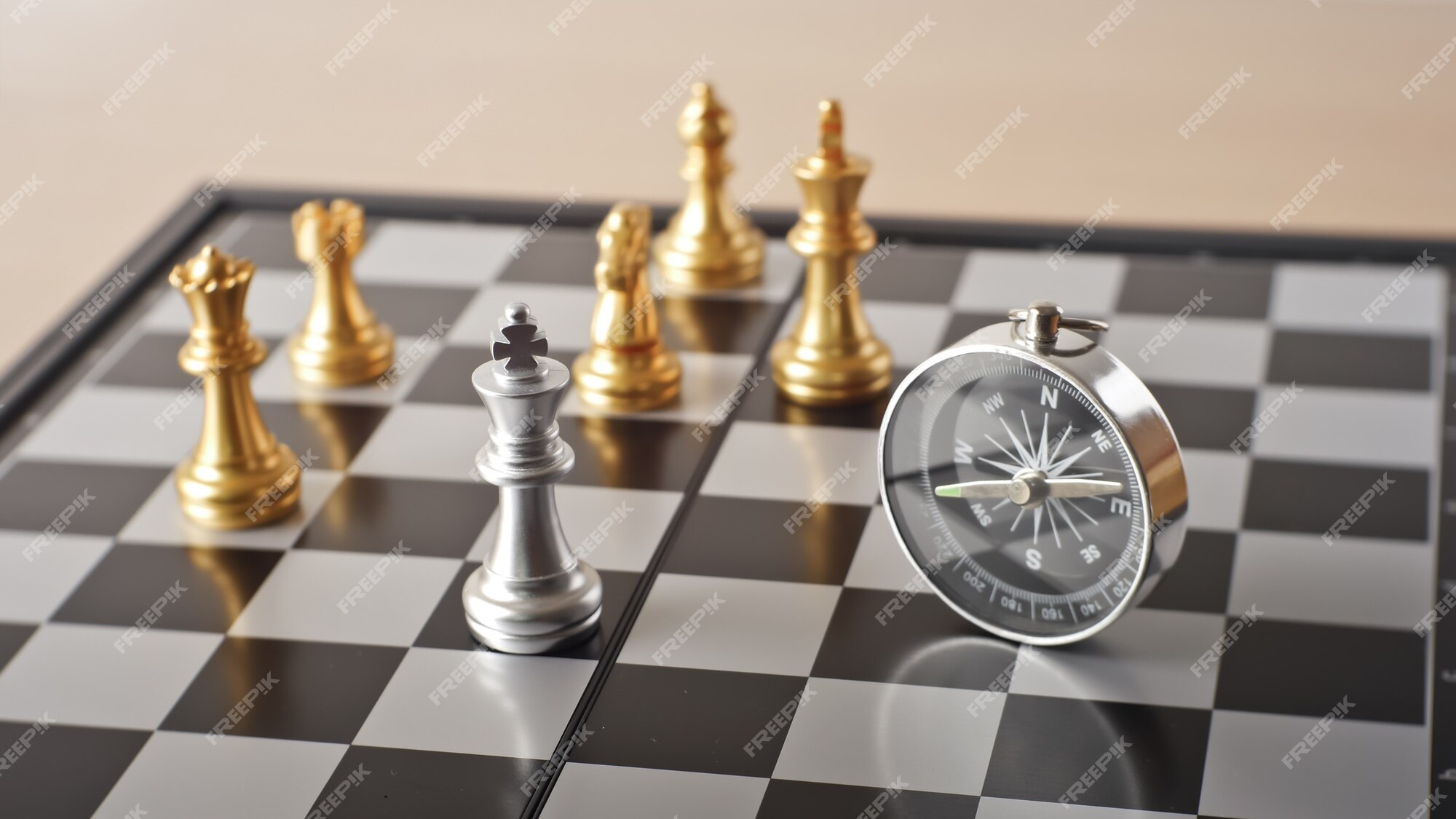 a compass on a map with chess pieces in the background and a light