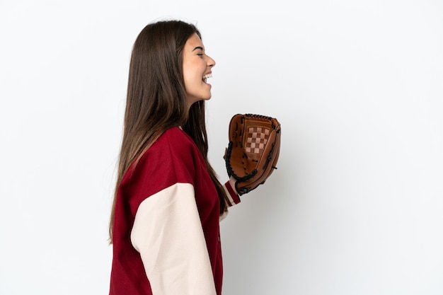 Бразильская женщина-игрок с бейсбольной перчаткой, изолированные на белом фоне, смеется в боковом положении