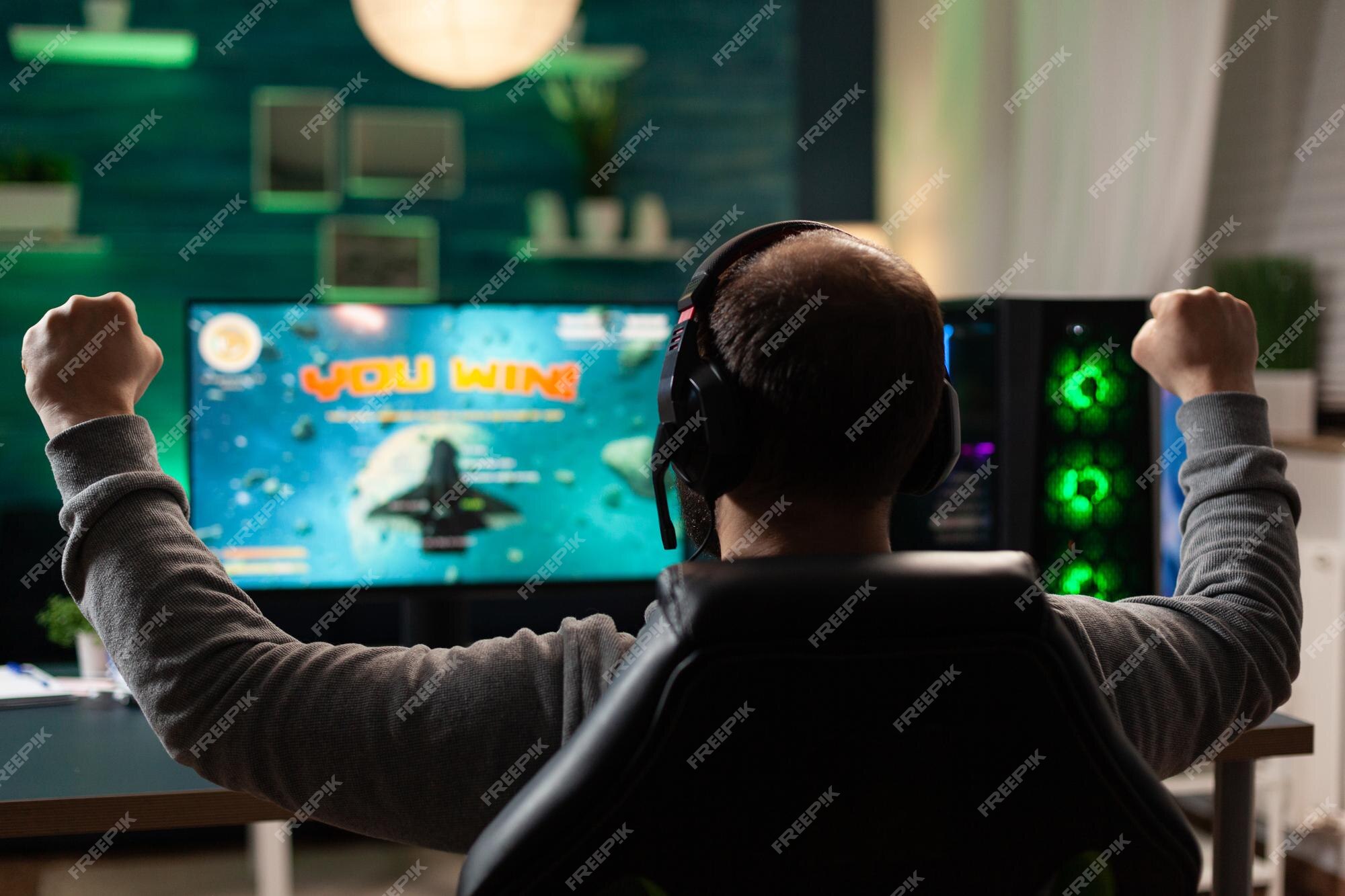 Free Photo  Player winning video games with controller and headset in  front of monitor. man using joystick and headphones, playing online games  on computer. person celebrating game win for leisure.