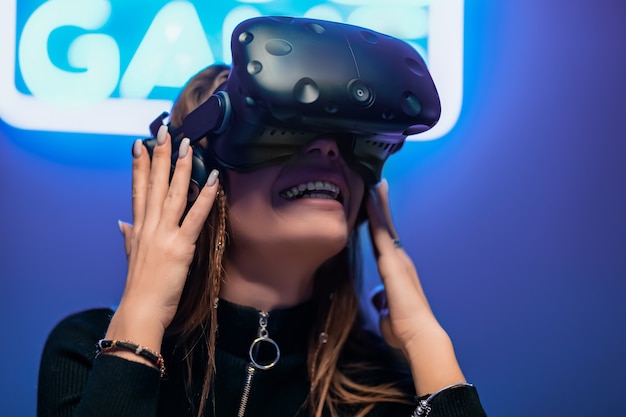 Игрок удивлен во время игры VR. Неоновая вывеска.