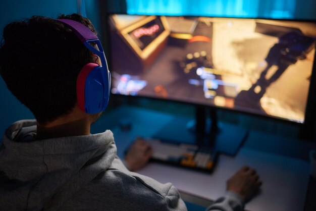 Photo player looking at his computer screen contemplating his next move in an online video game