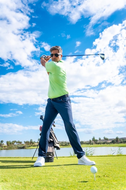 Un giocatore che gioca a golf su un campo da golf che colpisce la palla vicino a un lago