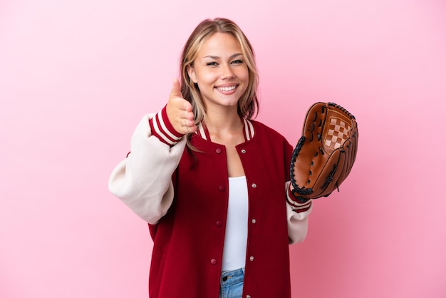 Player Russian woman with baseball glove isolated on pink background shaking hands for closing a good deal