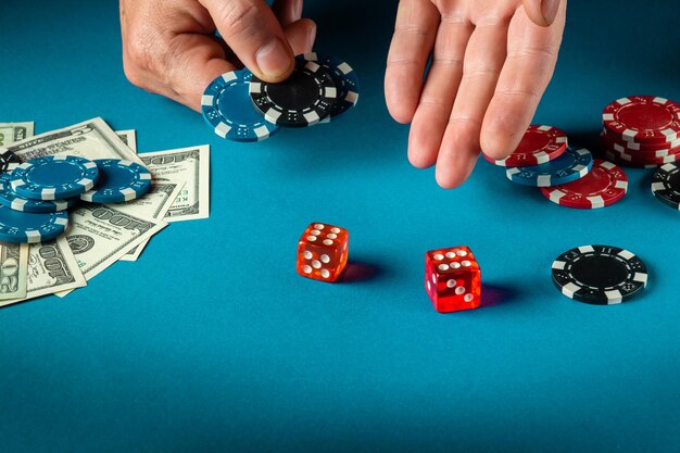 Photo the player throws the dice on the blue table in the poker club luck or fortune in the casino